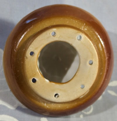 Bottom view of the reamer for a brown and tan monkey head juicer