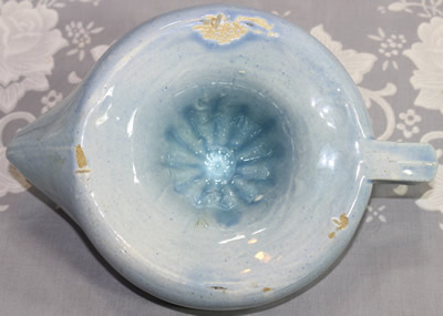 The base of a blue Sunkist like ceramic juicer