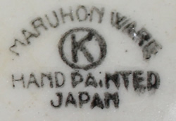 Basemark on yellow loop handle juicer with white flower and green leaves