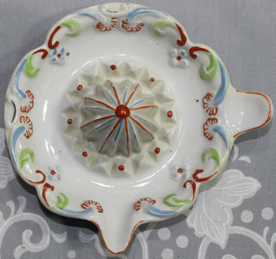 Top view of blue, red & green on white ceramic saucer juicer