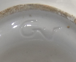 Incised mark on a yellow and green on white fish juicer