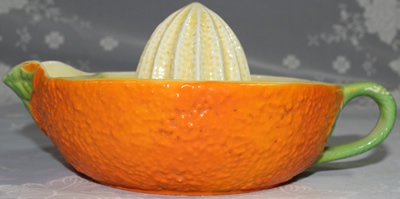 Side view of large orange and cream, green handle, Crown Devon juicer