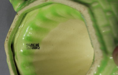 The base of a pale green and yellow Japanese Carlton Ware copy basket weave juicer 