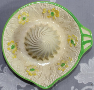 Base mark on yellow flowers on cream & green ceramic saucer juicer