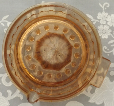 Top view of an amber glass with joined bead pattern juicer