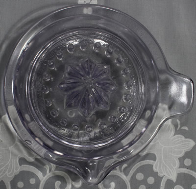 Top view of am amethyst Canton Glass embossed Manny juicer without flash