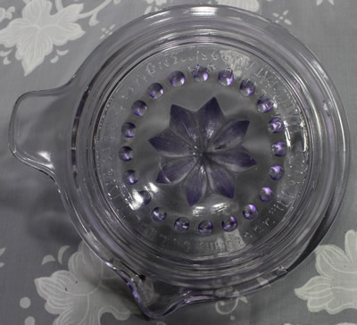 Bottom view of am amethyst Canton Glass embossed Manny juicer without flash 