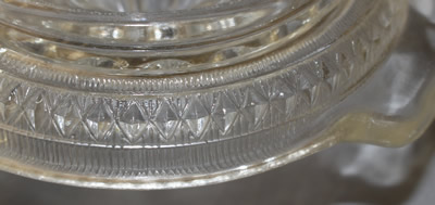 A close-up of a diamond pattern clear glass juicer