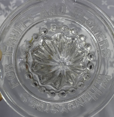 Closer view of W HANDYSIDES FOR FRUITS AND FLOWERS embossed on clear glass saucer juicer 