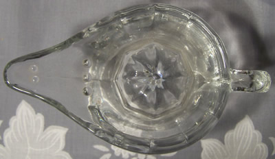 Top view of a small raised handle Alladin's lamp clear glass juicer