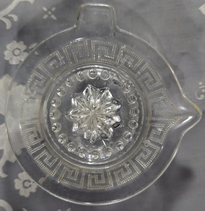 Top view of a Greek key pattern clear glass juicer