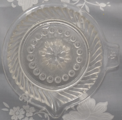 Top view of a stylised eagle tab handle clear glass juicer