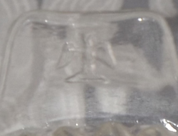 The stylised eagle on the tab handle of a clear glass juicer
