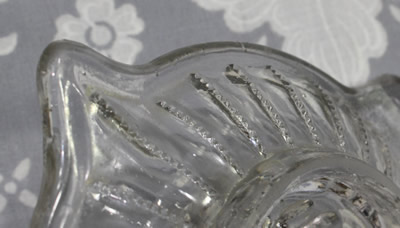 A close-up of the vertical lines of small pyramids on a 1 piece clear glass juicer 