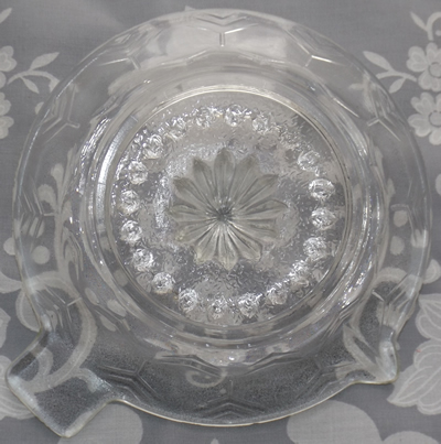 Bottom view of a clear glass stylised tree pattern juicer