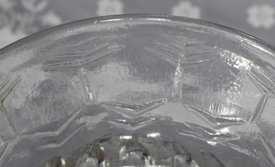 Close view of a clear glass stylised tree pattern juicer