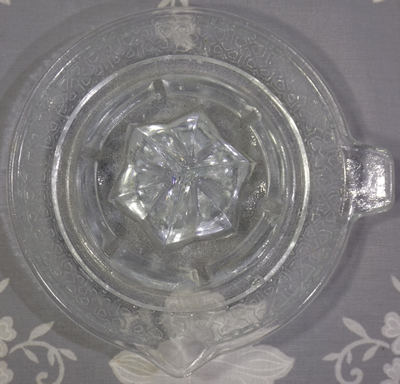 Clear glass juicer with endless knot pattern top view