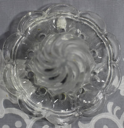 Top view of a spiralled clear glass juicer top