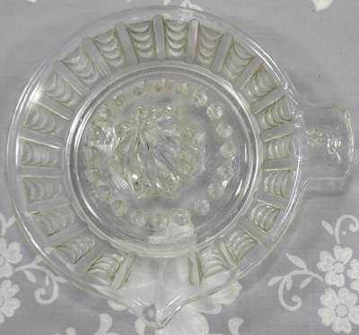 Top view of a clear glass with flower on tab handle juicer