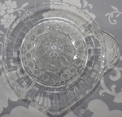Top view of a speckle hammer crossing a sword tab handle saucer clear glass juicer