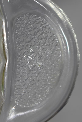 The hammer crossing a sword on a speckle tab handle on a saucer clear glass juicer