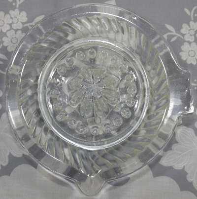Top view of a flat rim sloping flutes saucer shape clear glass juicer