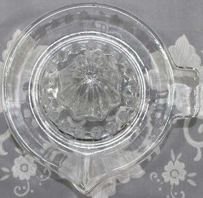 Top view of a lear glass saucer shape juicer with 30 panels