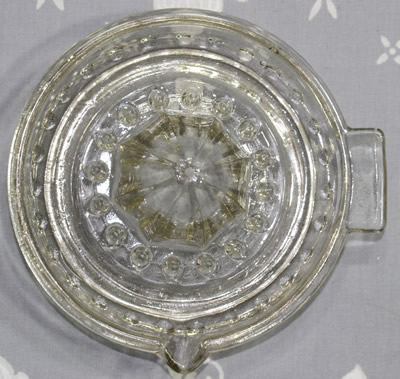 Top view of a clear glass linked ball pattern juicer