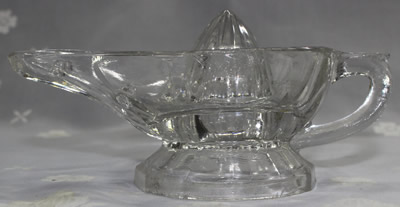 Side view of a flat handle Alladin's lamp clear glass juicer