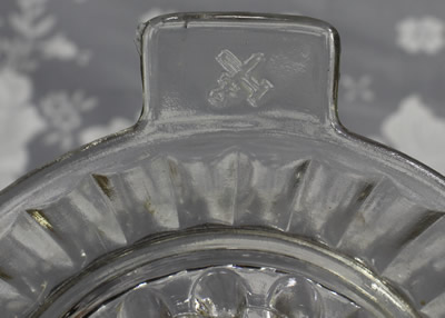 Showing the crossed hammer and sword on a clear glass saucer shape juicer