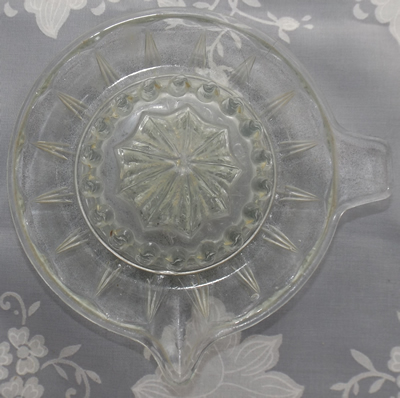 Top view of an embossed Rd DESIGN No 25239 clear glass saucer juicer