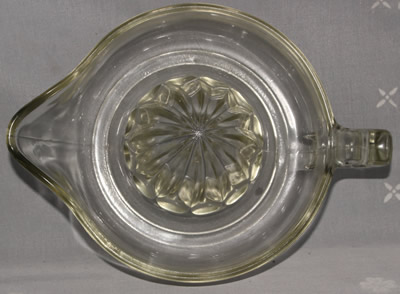 Top view of a large unembossed clear glass loop handle juicer