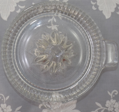 Top view of an Anchor Hocking clear glass fluted tab handle juicer