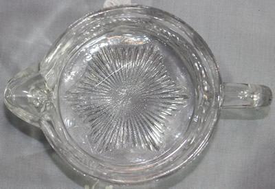The jug base for a Westmoreland Specialty Co. clear glass 2 piece cup juicer