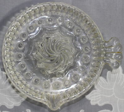 Top view of a clear glass spiral reamer juicer with fan handle 