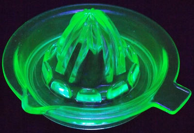 A green Hazel Atlas saucer spiral juicer under UV light