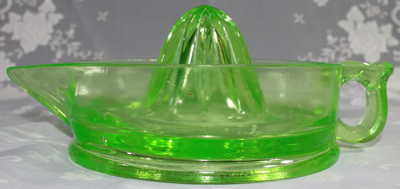 Side view of a Cambridge Glass Company jug like green glass juicer