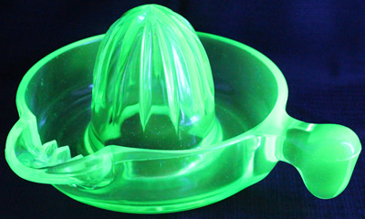 An offset tear drop handle green glass US Glass Co. juicer under UV light 