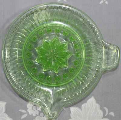 Top view of a green glass arrowheads pointing at small circles juicer