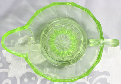 Top view of a small 14 panel green glass jug like juicer 