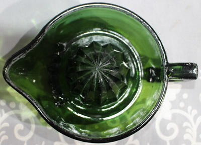 Top view of a square handle emerald green glass juicer