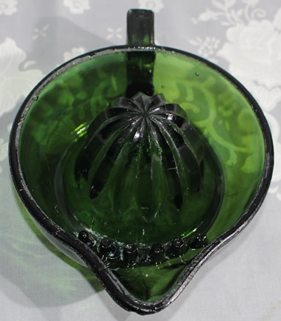 Showing pip collectors on a square handle emerald green glass juicer