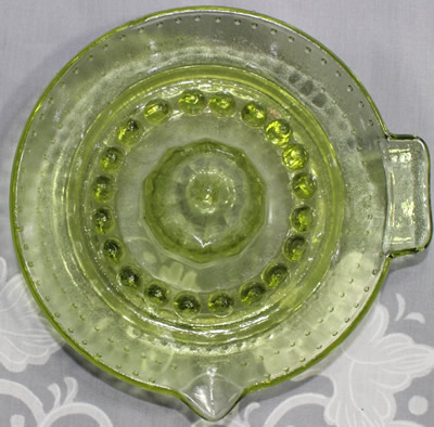 Top view of a smaller hobnail green glass saucer shape juicer