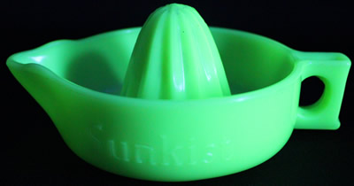 A straight handle jadeite SUNKIST juicer under UV light
