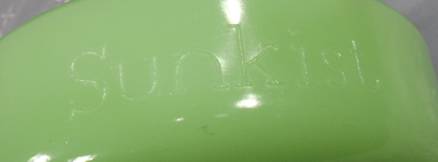 Embossed face of a round handle jadeite SUNKIST juicer