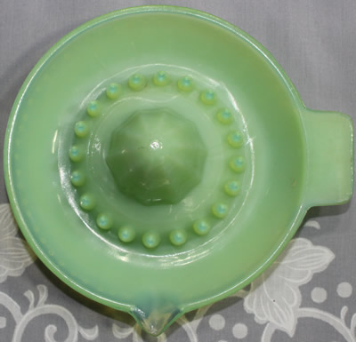 Top view of a hobnail jadeite with clear glass saucer shape juicer