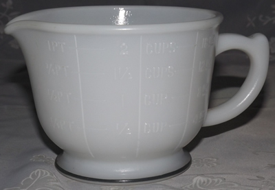 Front of a Hazel Atlas white milk glass with Green band juicer jug