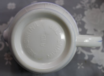 Embossed base on a Hazel Atlas white milk glass with blue band juicer jug
