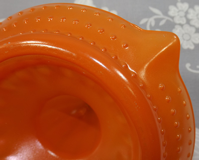 Showing hobnail on fired on orange glass juicer
