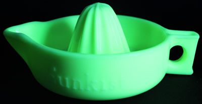 A light seville yellow straight handle Sunkist juicer under UV light